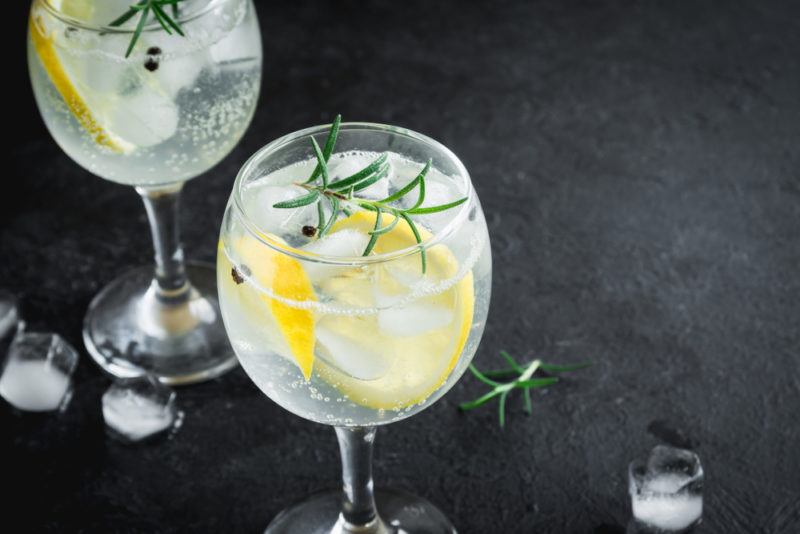 Two glasses of a gin and tonic with ice, rosemary and lemon slices