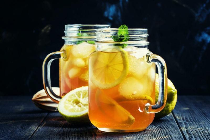 Two mason jars containing a gin and mint tea cocktail