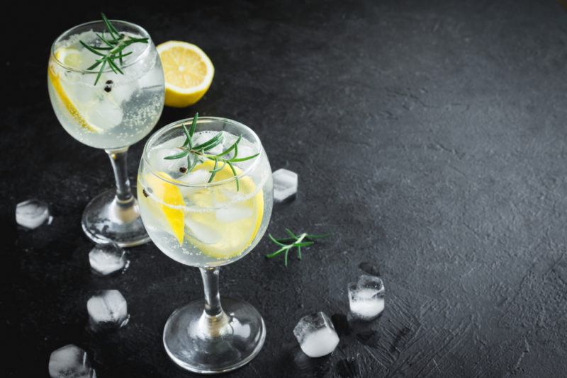 Two glasses of gin and tonic on a black background