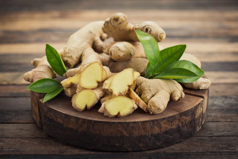 Ginger roots and sliced ginger on a cutting board