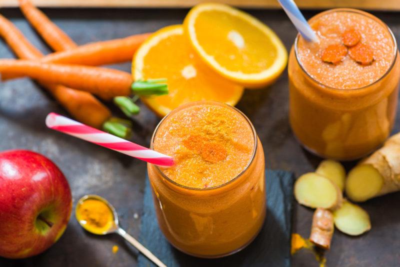 Two glasses with ginger turmeric and carrot juice