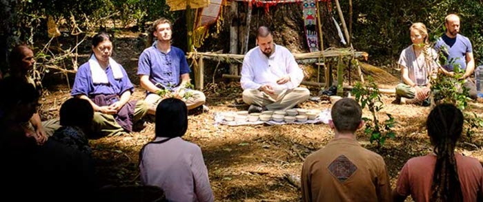 A group of men and women in a circle with crossed legs. 