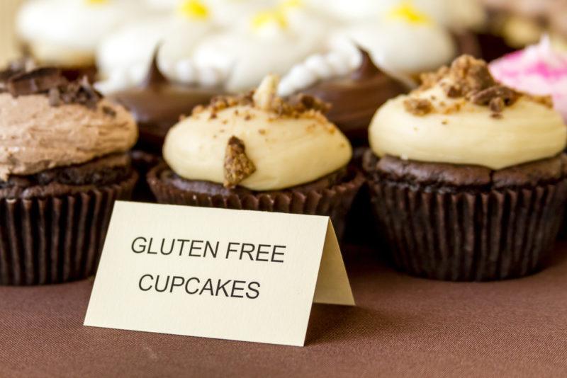 A selection of gluten free cupcakes with a label on a table