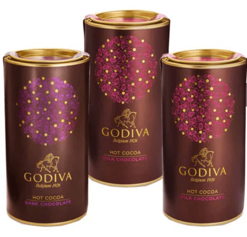 Three canisters of godiva hot chocolate, two are milk chocolate and the third is dark chocolate