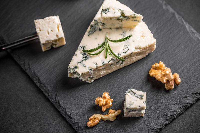 Gorgonzola cheese with walnuts on a black slate