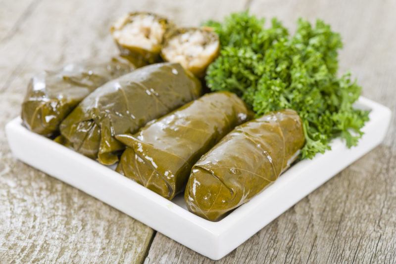 A white plate with stuffed grape leaves