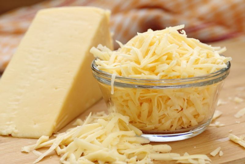 A block of cheese and some grated cheese