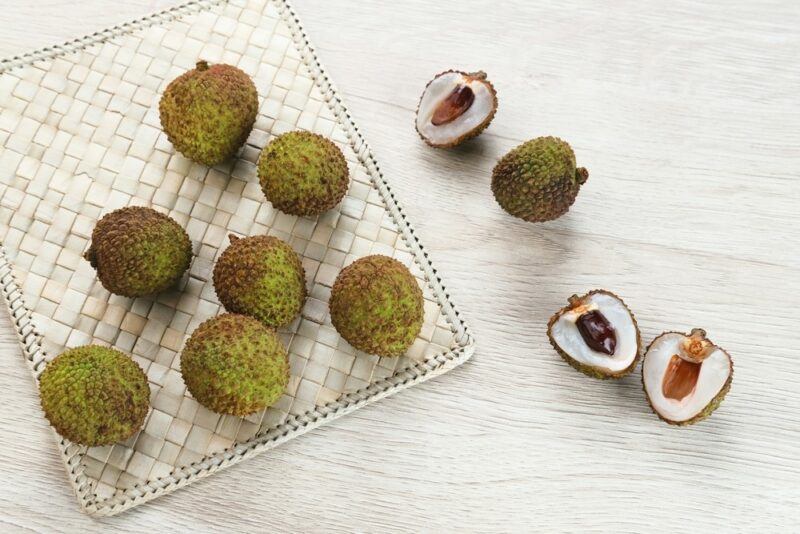 A tray with a variety of whole green lychees, plus three lychee halves