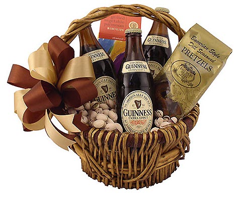 Small basket with 3 bottles of Guinness and a few snacks. 