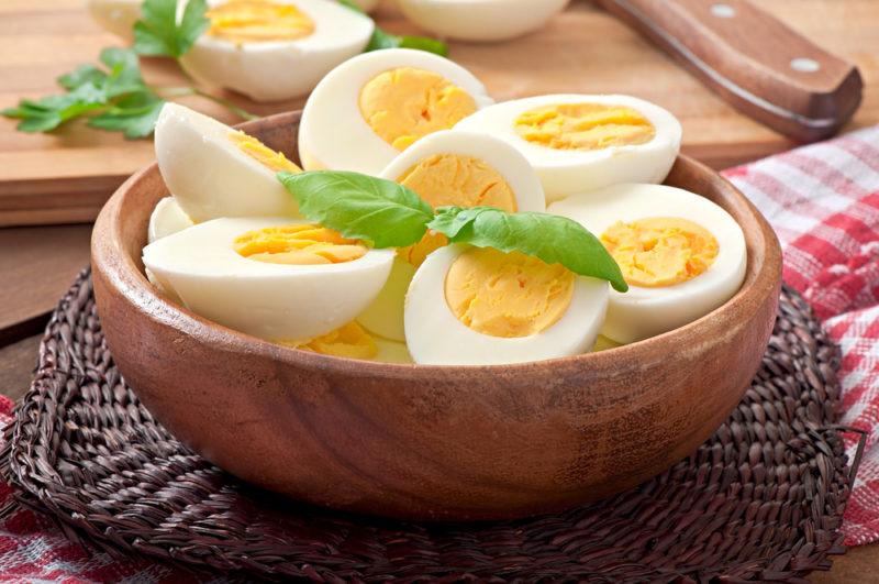 A wooden bowl containing hard boiled eggs