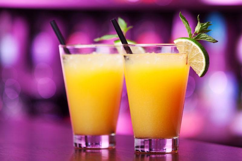 Two Harvey Wallbanger cocktails in front of an out-of-focus bar