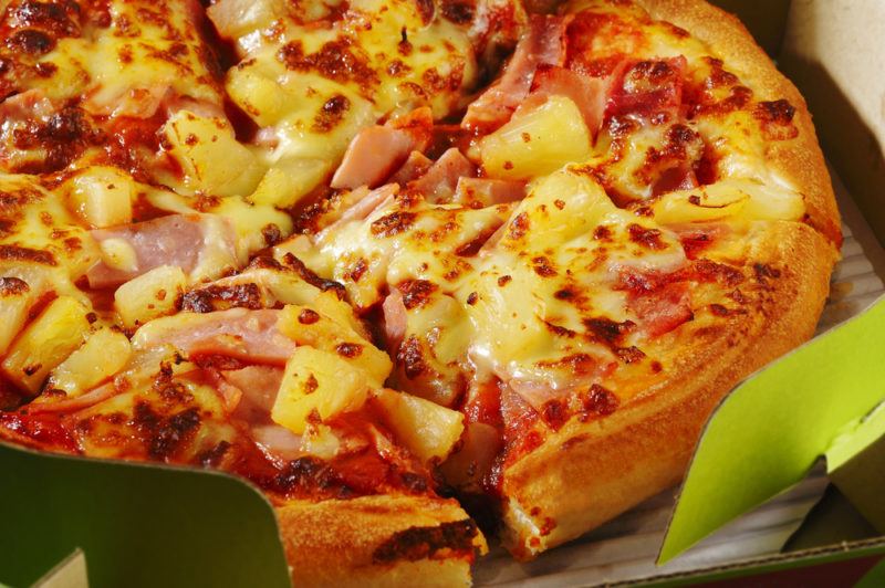 An Hawaiian pizza with ham and pineapple