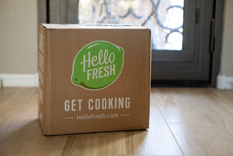 A Hello Fresh box in someone's entry way, showing the green Hello Fresh lime logo