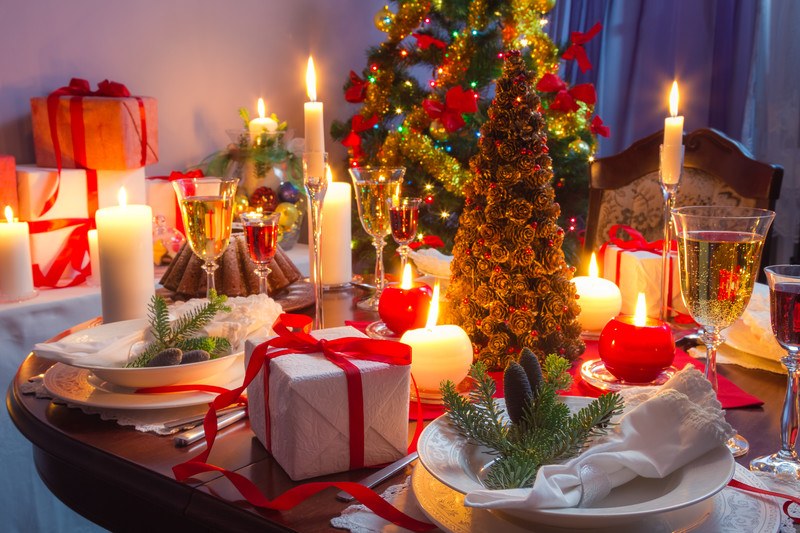 Table decorated with food and gifts for a candle light dinner for the holidays