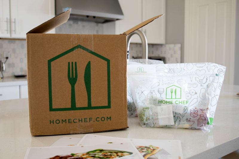 A Home Chef box on a counter next to bags with fresh ingredients