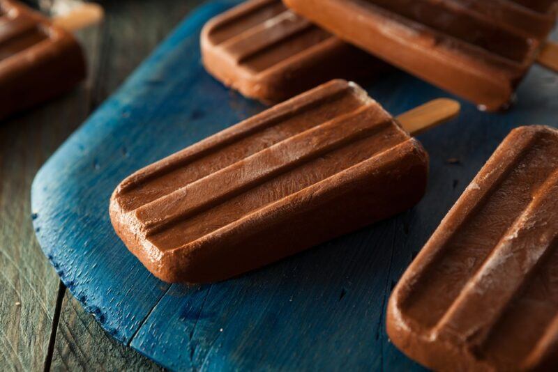 A bright blue tray with four homemade chocolate fudgesicles