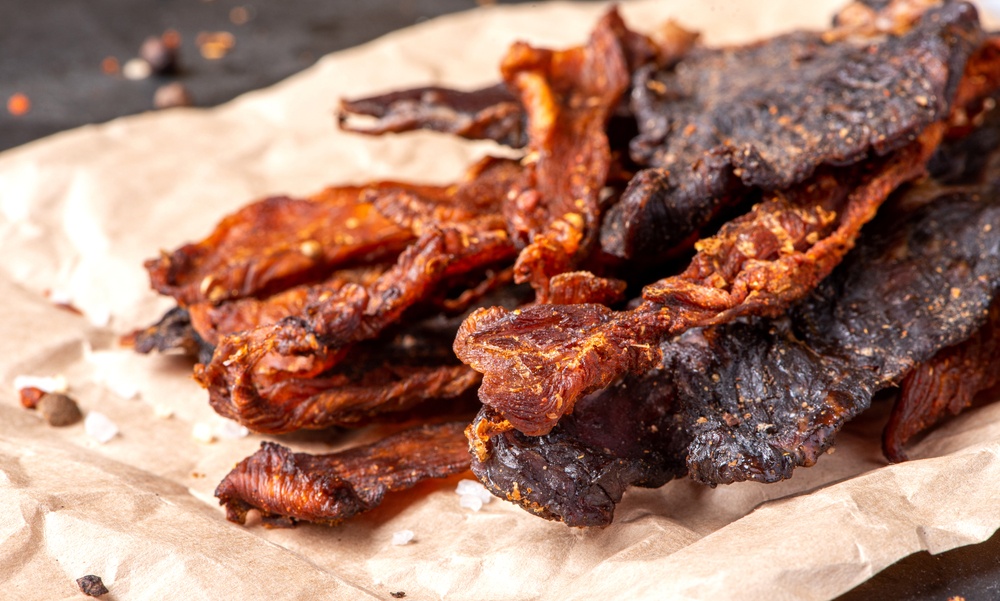 Homemade chicken and beef jerky on a piece of paper