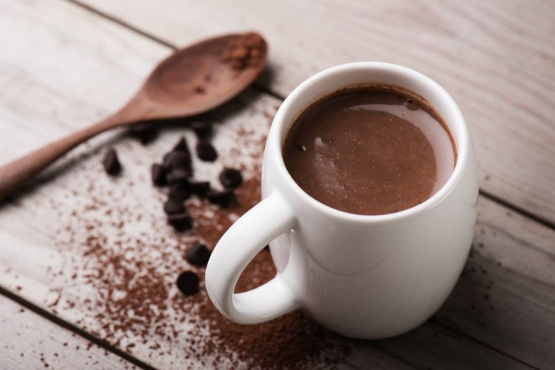 A mug of hot chocolate and a spoon