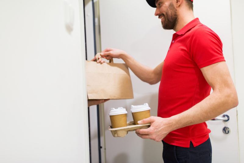 A man delivering hot coffee and food to an apartment