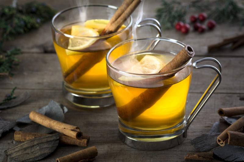 Two hot toddies in glass mugs with cinnamon sticks