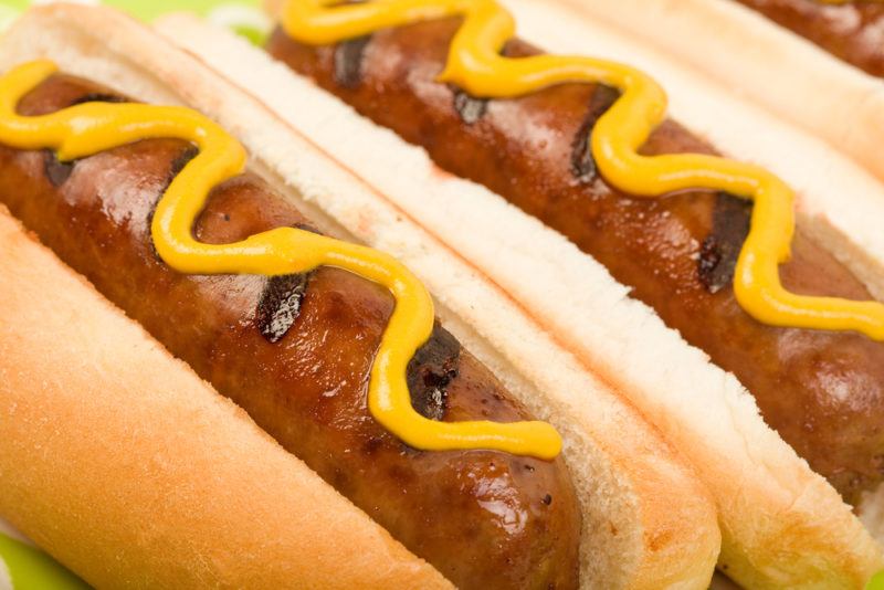 Hot dog buns with hot dogs and mustard | Food For Net Two hot dog buns, with hot dogs and mustard