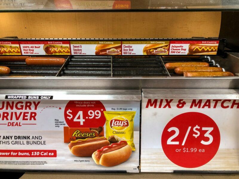 A display of fresh hot dogs at a gas station, including information about prices