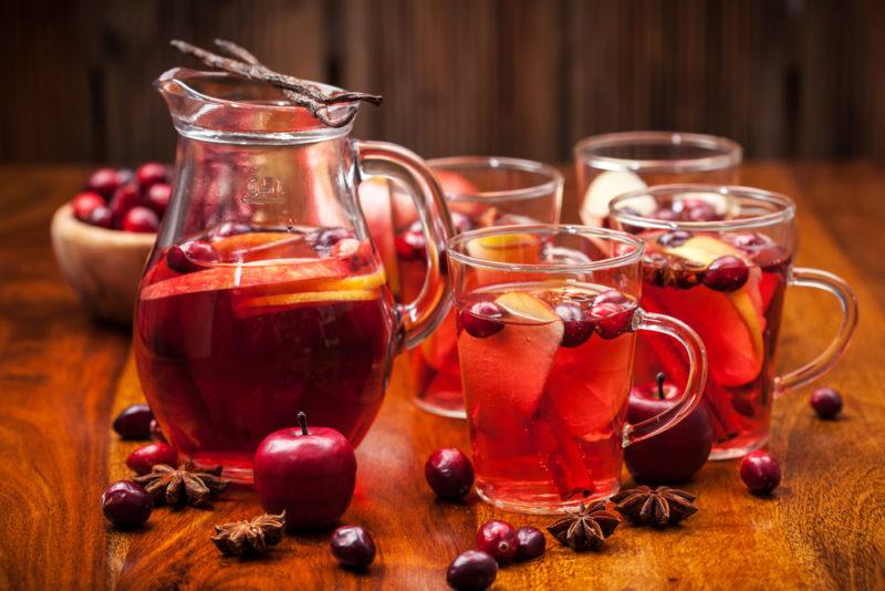 A jug of hot punch with various glasses of punch