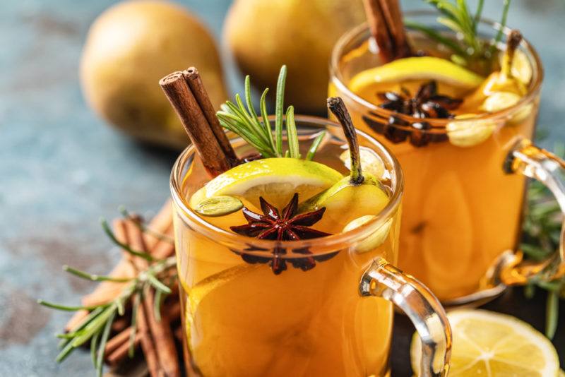 Two glass mugs with hot toddies and spices