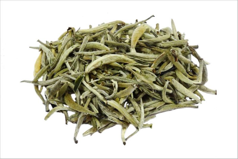 a closeup image of a pile of Huo Shan Huang Ya or Amber Mountain tea on a white background