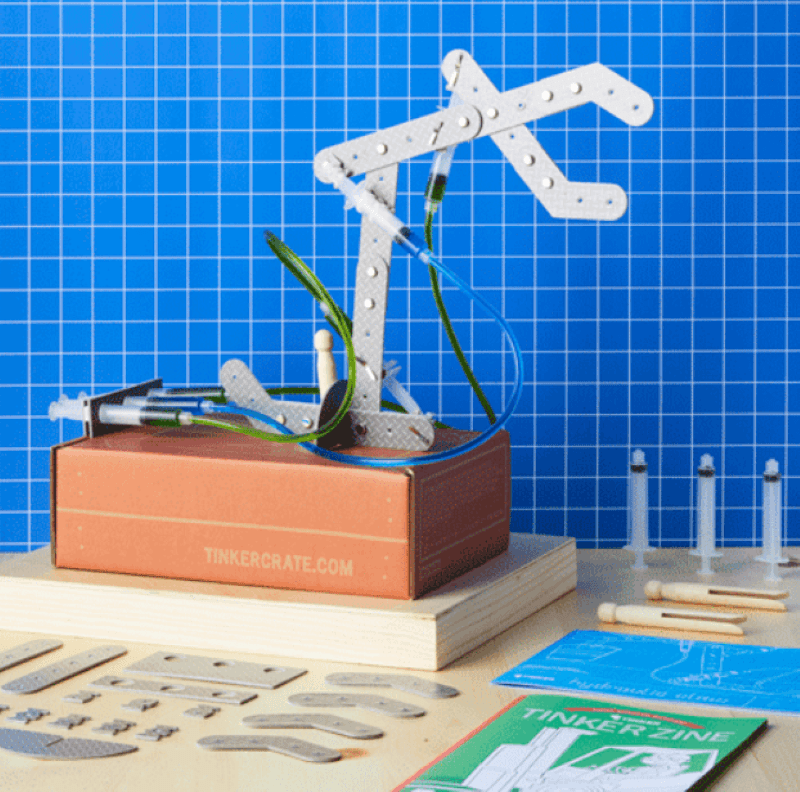 Hydraulic crane from the tinker crate from Kiwi Co. Shows tools, parts, and Tinker Zine book