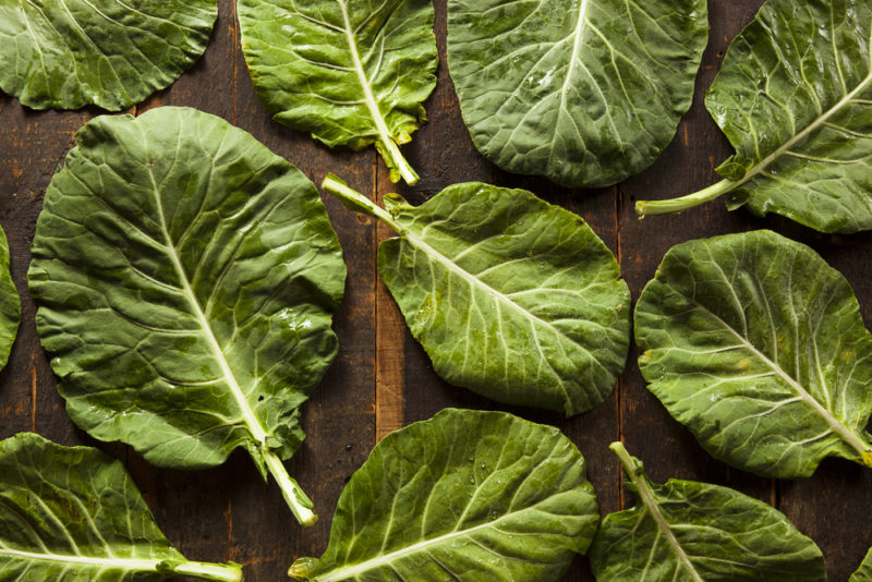 Collard green leaves on a wooden table