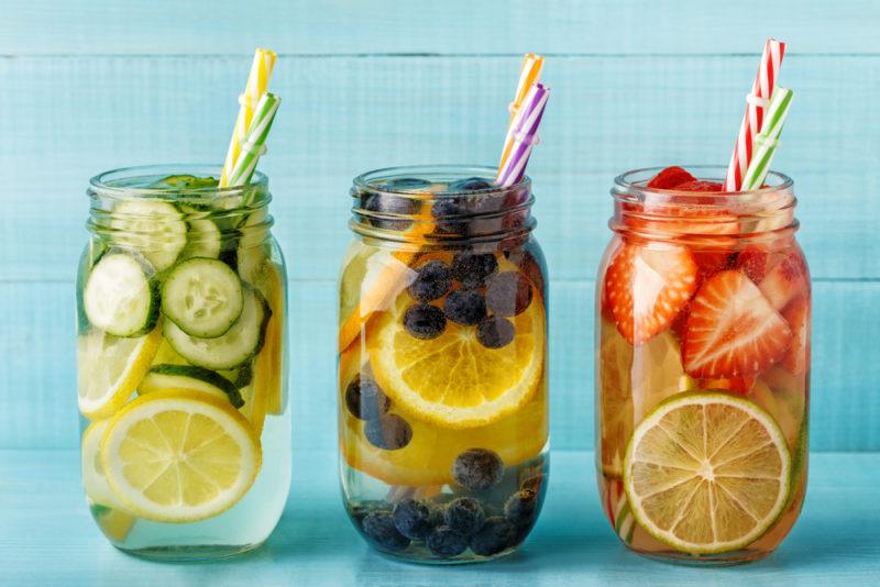 Three mason jars with straws containing various types of infused water