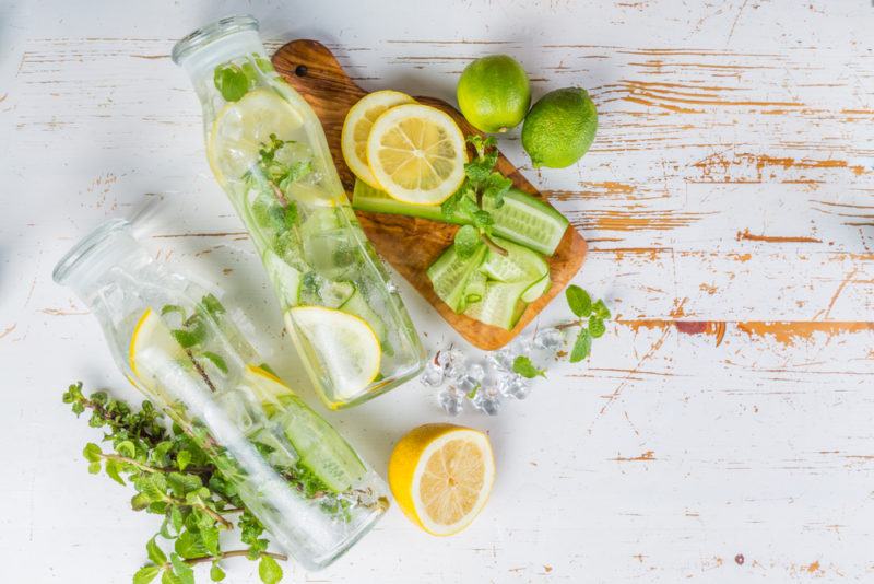 A top down image of two diffuser bottles, along with various fresh ingredients