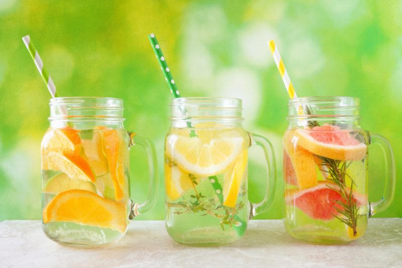 Three maon jar mugs with fruits and straws to make infused water