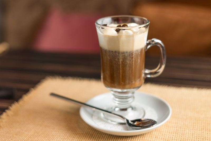 An Irish coffee cocktail in a glass on a saucer