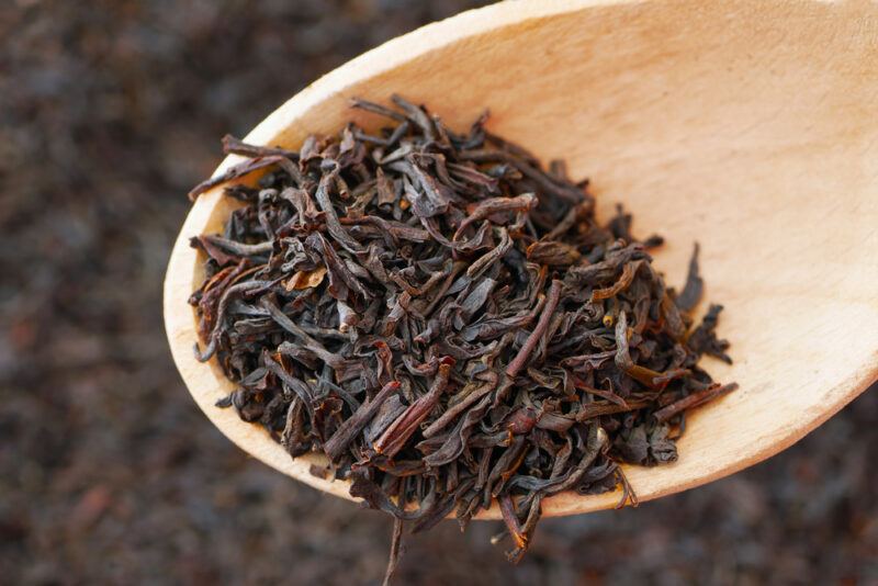 closeup image of a wooden spoon with Irish breakfast tea above a spread of loose Irish breakfast tea