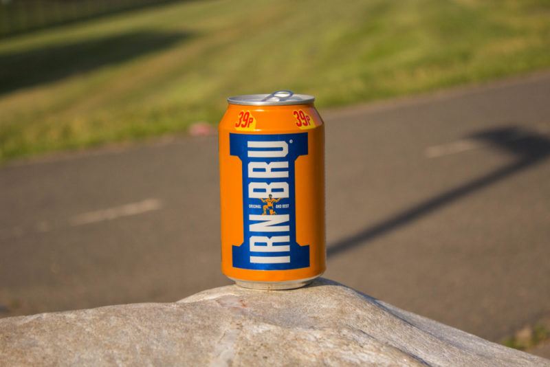 A can of Irn Bru next to a road