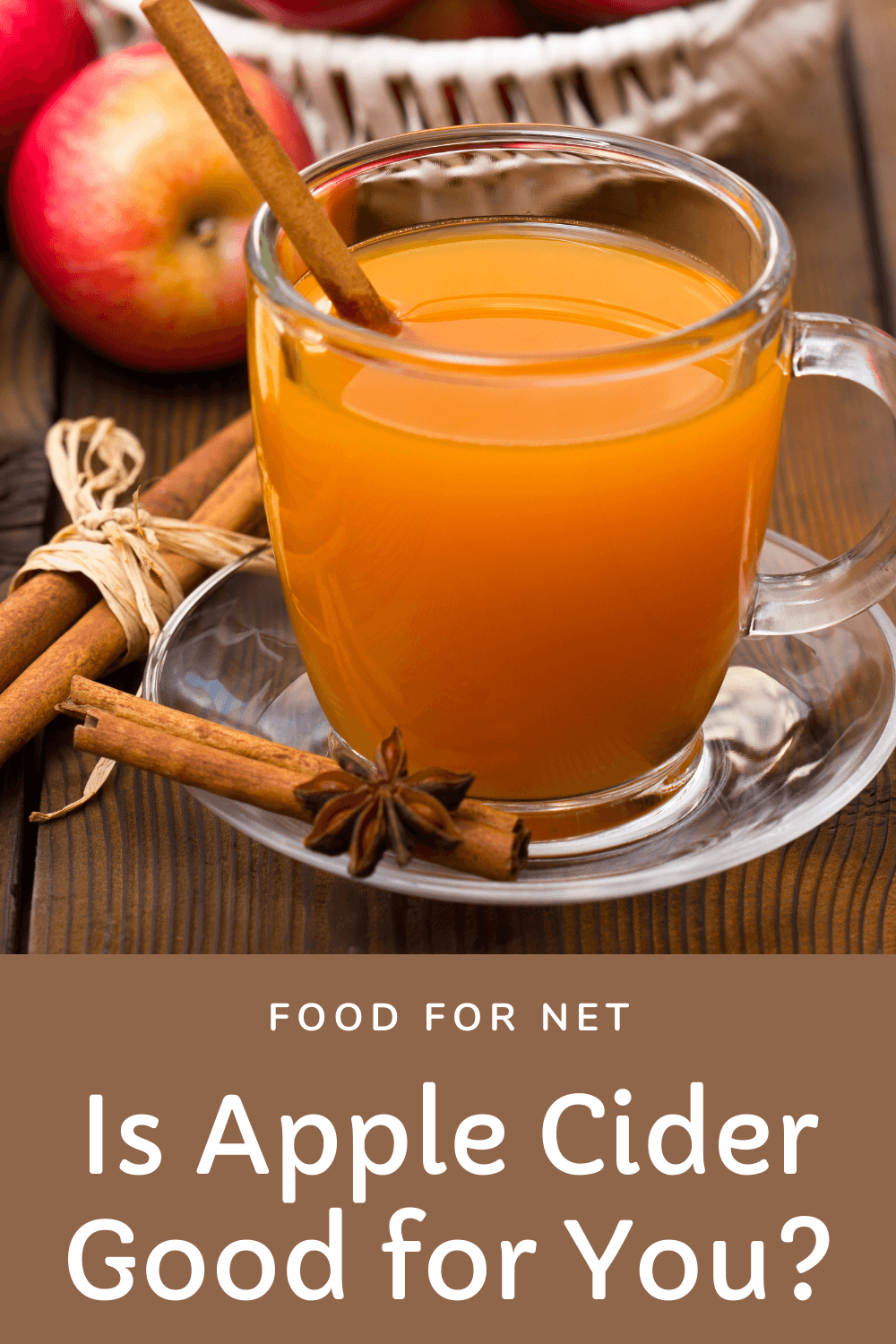  Una taza de vidrio de sidra de manzana delante de algunas manzanas y canela