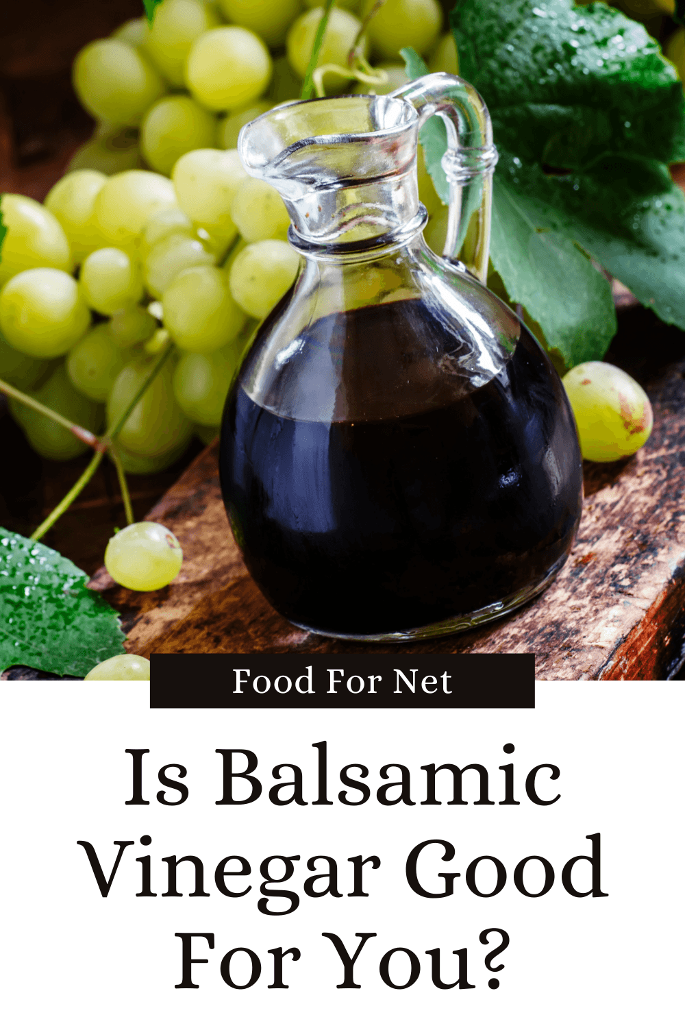 A glass jug of balsamic vinegar in front of fresh green grapes, looking at whether balsamic vinegar is good for you