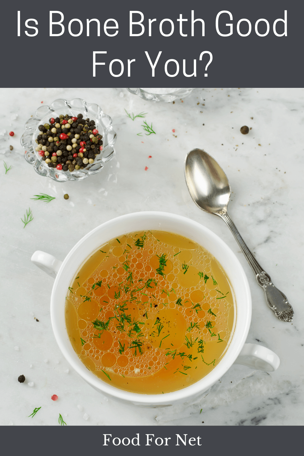 Is Bone Broth Good For You? A white bowl or mug of bone broth on a table next to a spoon and some pepper