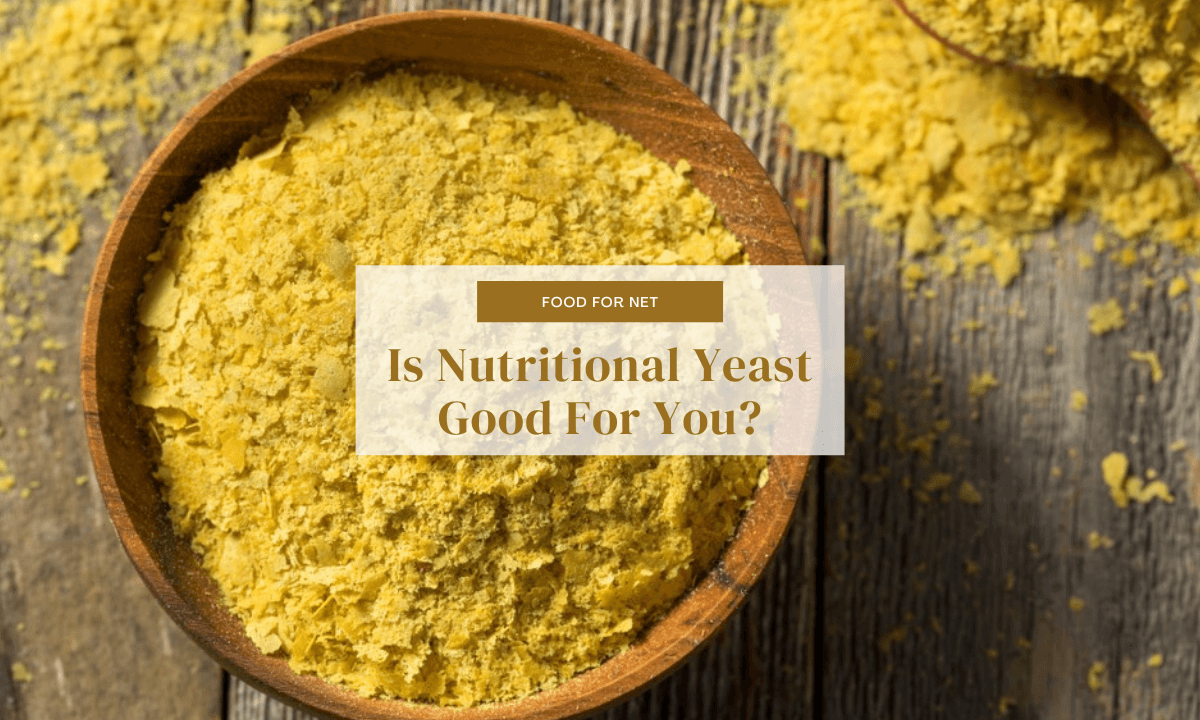 A large brown bowl of nutritional yeast on a wooden table