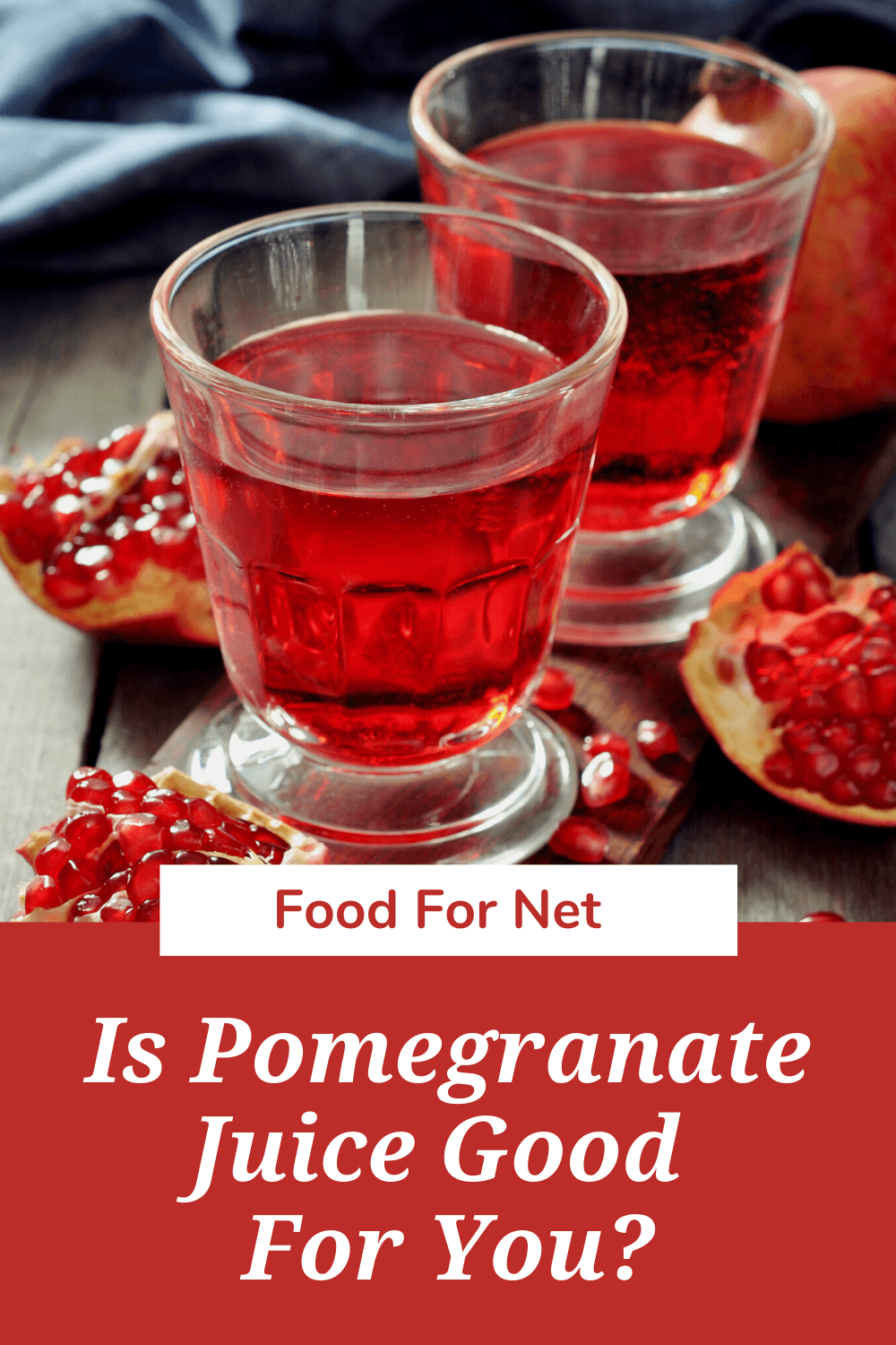 Two glasses of pomegranate juice on a table, next to some pomegranates