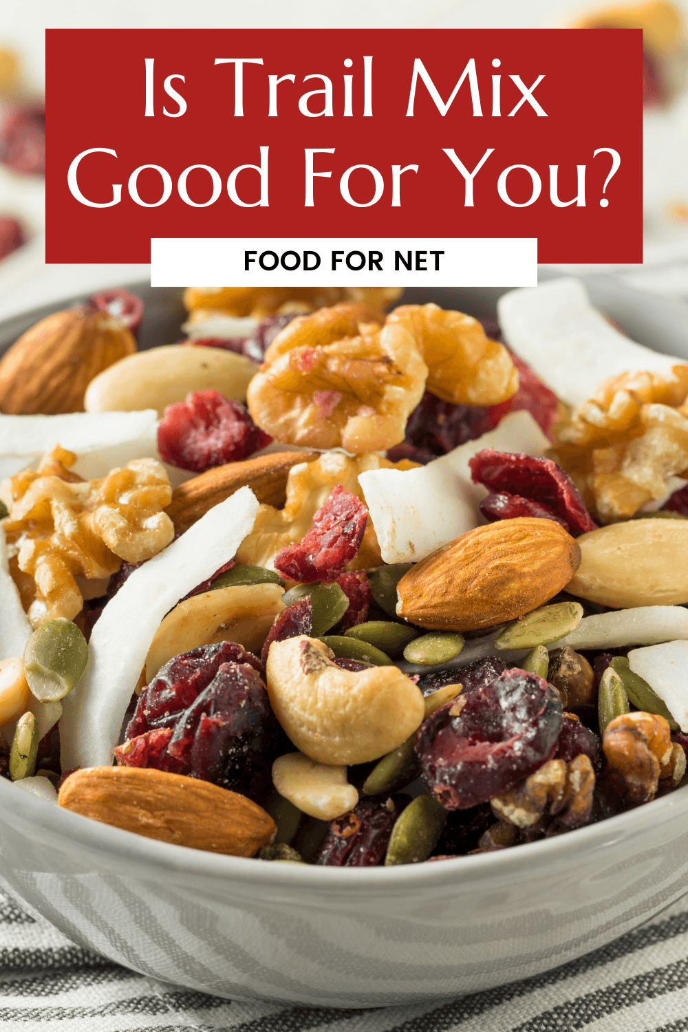 A large bowl of trail mix, including nuts, coconut, and dried fruit, considering whether it is good for you