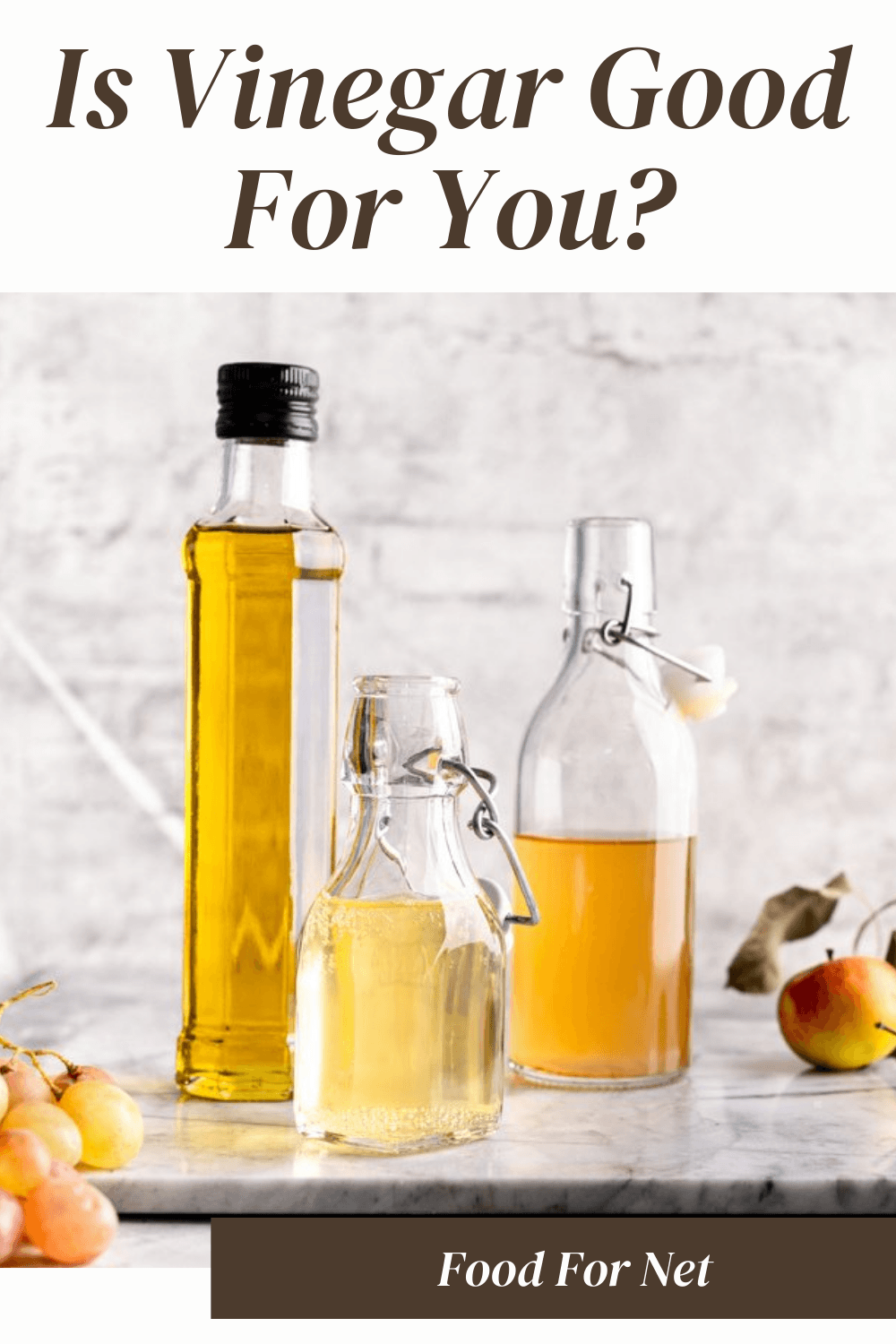 Is Vinegar Good For You? Three glass bottles filled with vinegar, next to some grapes and apples