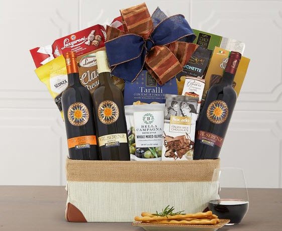 A basket containing 3 bottles of wine and a selection of snacks