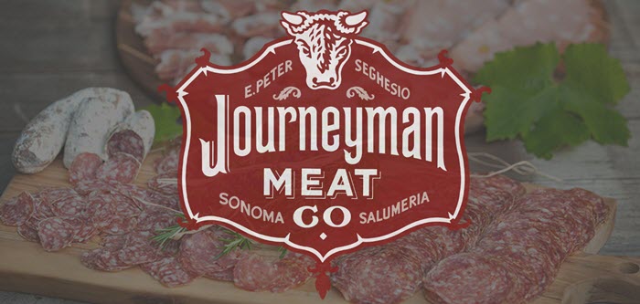 Cut up salami on a board behind the Journeyman logo