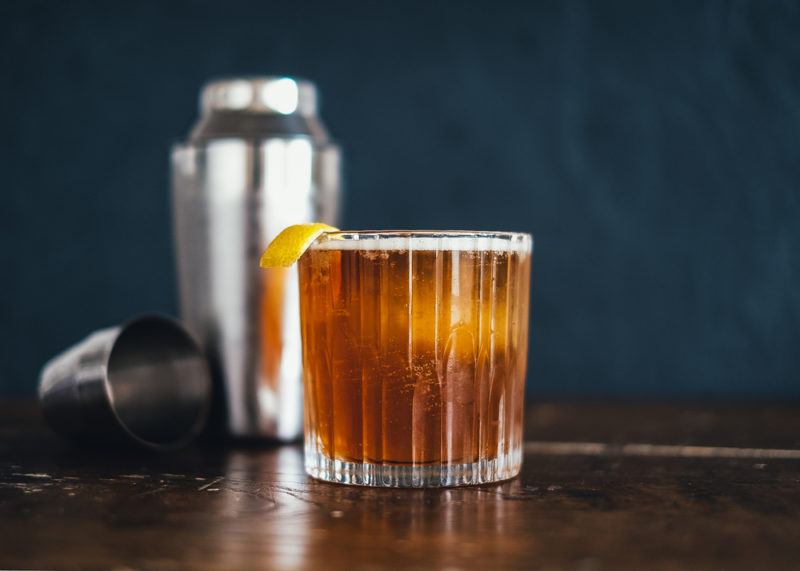 A Kahlua sour in front of a cocktail shaker