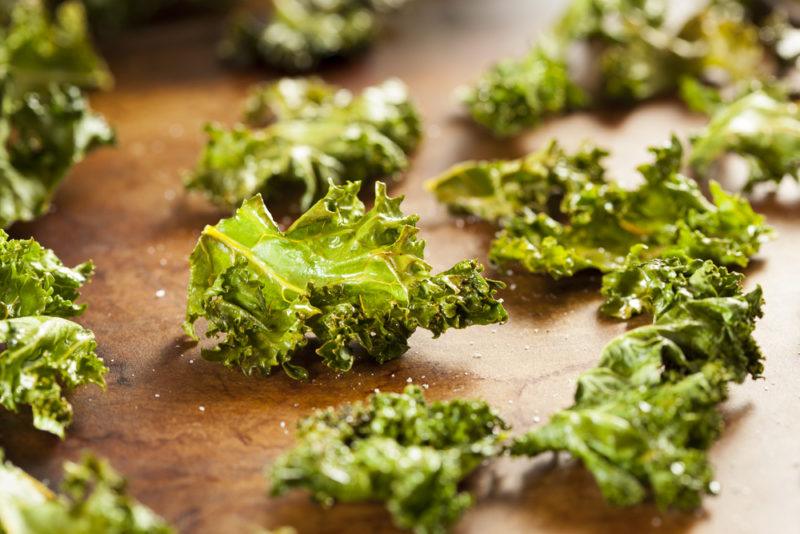 A selection of kale chips on a wooden board