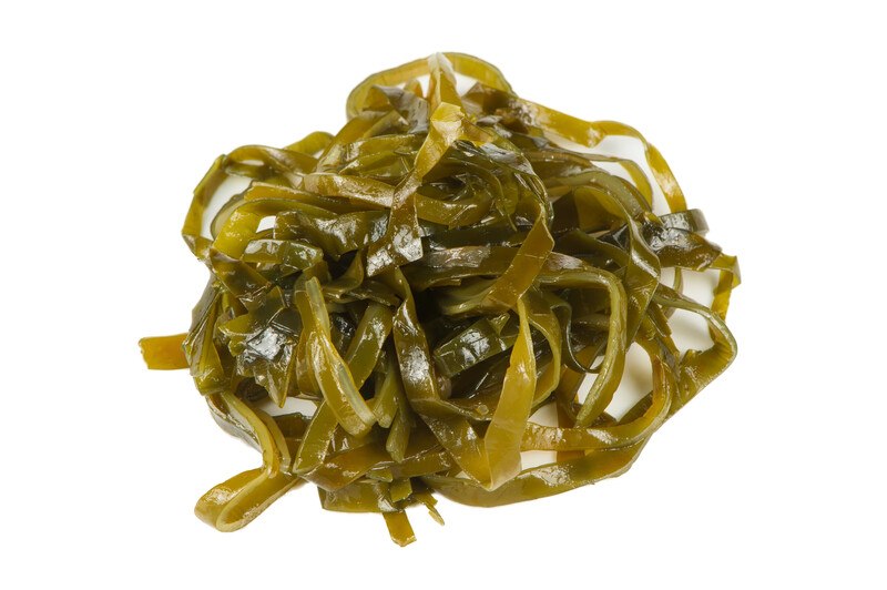 A pile of brownish-green kelp rests against a white background.