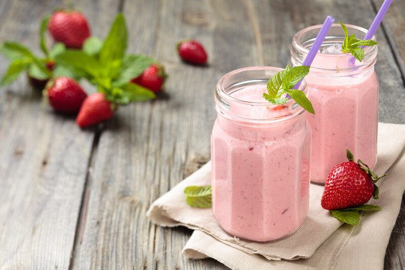 Keto Strawberry Smoothie Recipes | Food For Net Two strawberry smoothies on a wooden table.